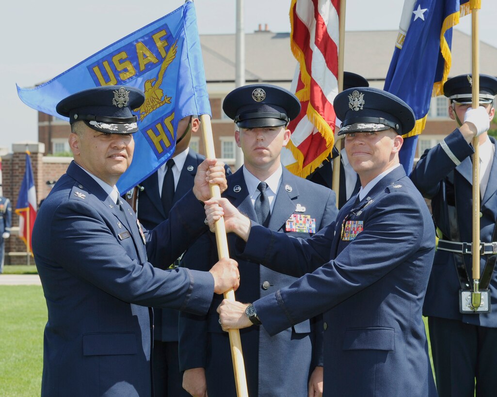 Lt. Col. Timothy Thurston II, right, outgoing U.S. Air Force Honor Guard commander, passes the U.S. Air Force Honor Guard guidon to Col. Richard Lindlan, 11th Operations Group commander, during a change of command ceremony June 12, 2015, at Joint Base Anacostia-Bolling, D.C. While in command, Thurston led more than 210 Airmen in more than 3,000 Air Force and joint-service ceremonies performed annually for the President, Secretary of Defense, Secretary of the Air Force, Chief of Staff of the Air Force and other dignitaries worldwide. (U.S. Air Force photo by Senior Airman Preston Webb/Released)
