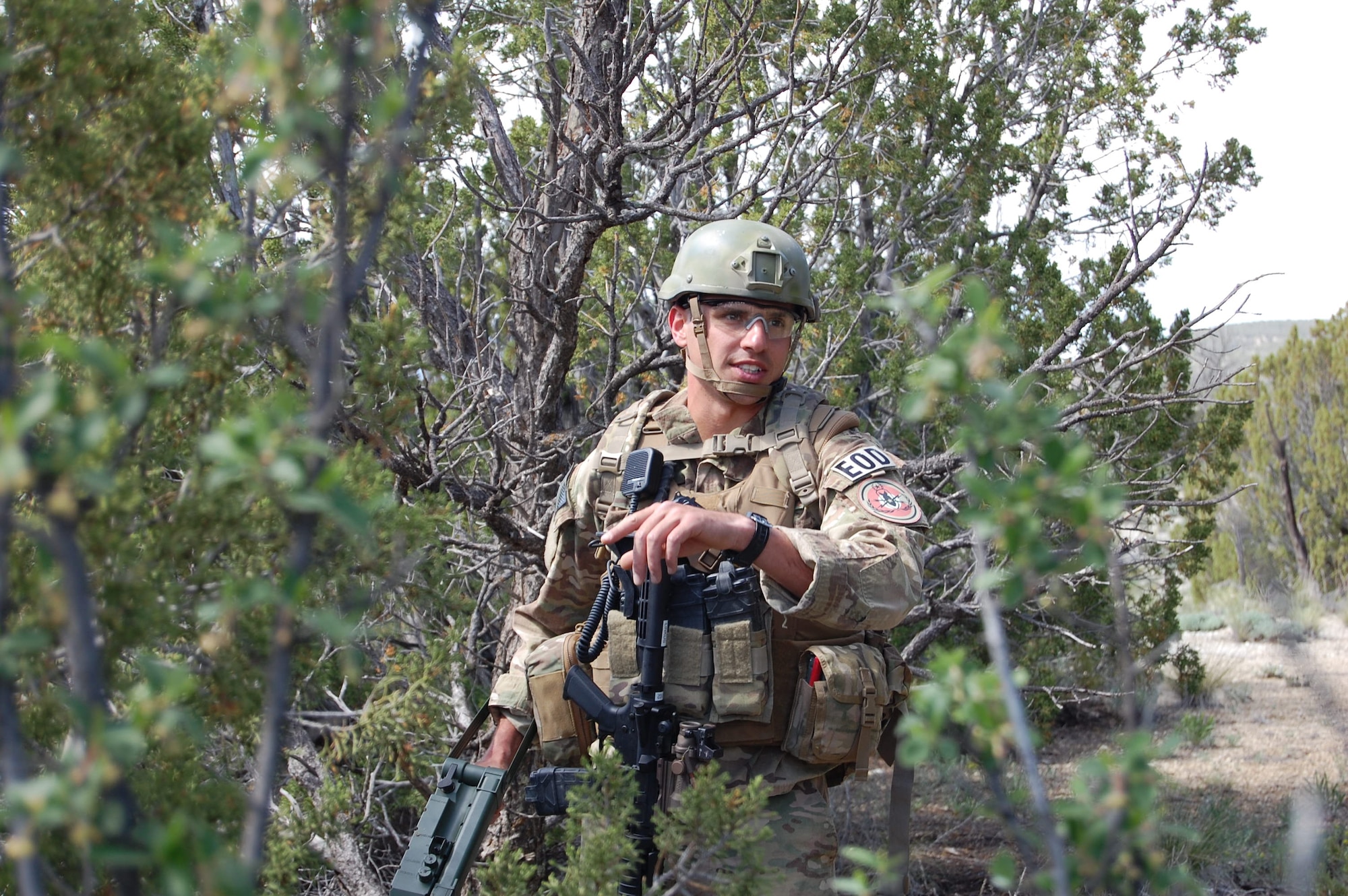 Senior Airman Darrell Linkus, explosive ordnance disposal operator with the 140th Explosive Ordnance Disposal Flight, 140th Wing, Colorado Air National Guard, communicates to his team about a weapon cache he found during a training exercise at Airburst Range, Ft. Carson, Colo. May 12, 2015.  (Air National Guard photo by Capt. Kinder Blacke)