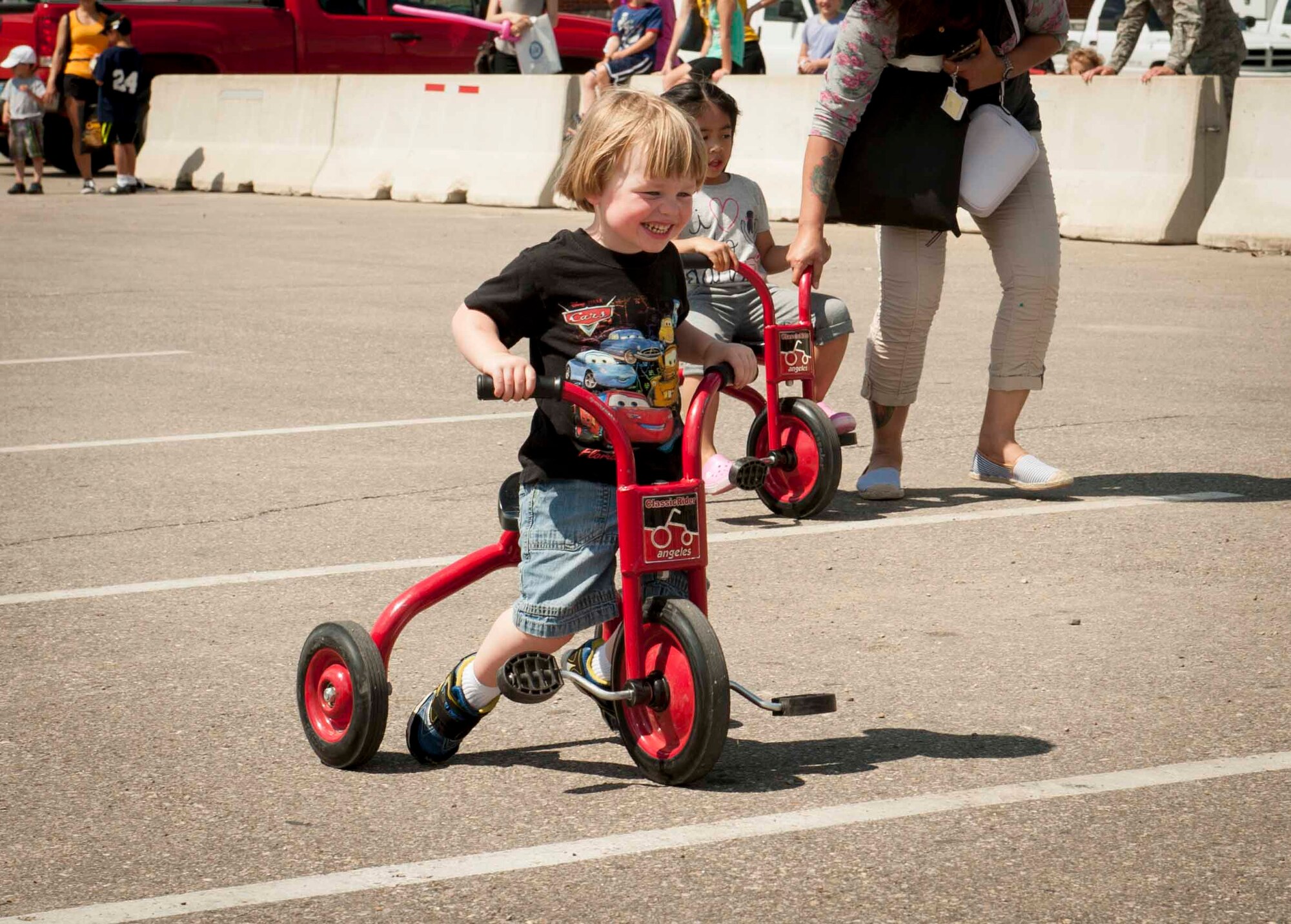 Boden Butler, age 3, participates in the children’s tricycle race at Minot Air Force Base, N.D., June 5, 2015. The competition was one of many activities held in the Rockers parking lot during the grand re-opening of the base’s most recently renovated restaurant. (U.S. Air Force photo/Airman 1st Class Sahara L. Fales)