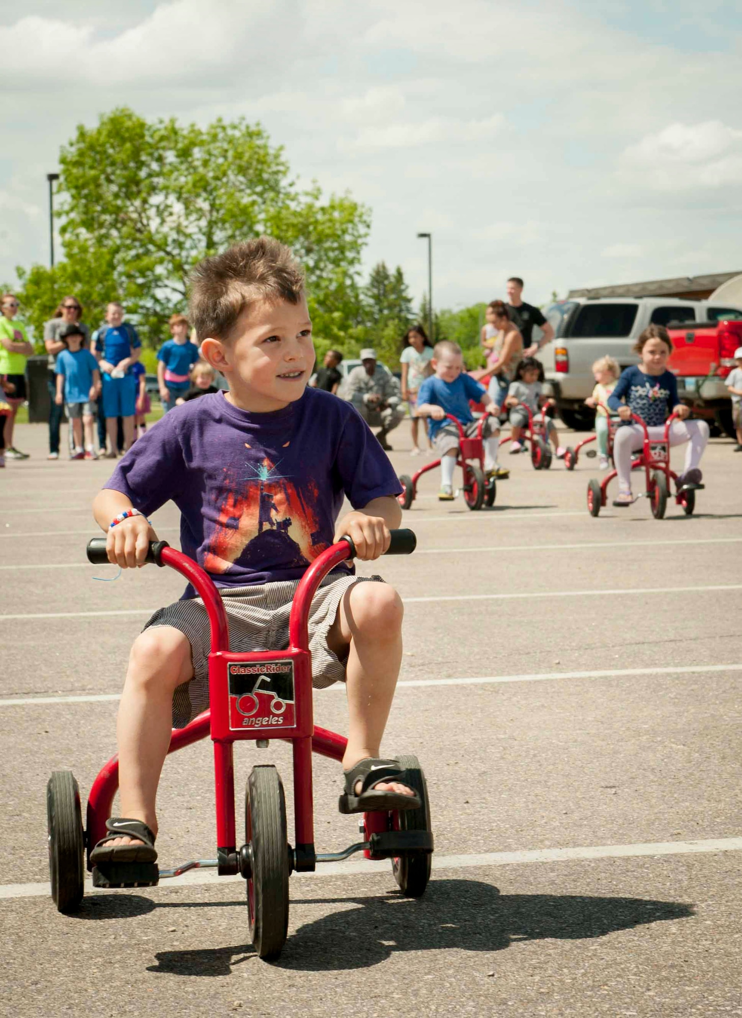 Paxton Austin, age 4, participates in the children’s tricycle race at Minot Air Force Base, N.D., June 5, 2015. The competition was one of many activities held in the Rockers parking lot during the grand re-opening of the base’s most recently renovated restaurant. (U.S. Air Force photo/Airman 1st Class Sahara L. Fales)