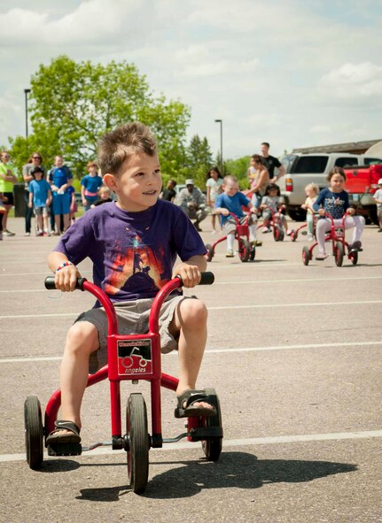 Paxton Austin, age 4, participates in the children’s tricycle race at Minot Air Force Base, N.D., June 5, 2015. The competition was one of many activities held in the Rockers parking lot during the grand re-opening of the base’s most recently renovated restaurant. (U.S. Air Force photo/Airman 1st Class Sahara L. Fales)