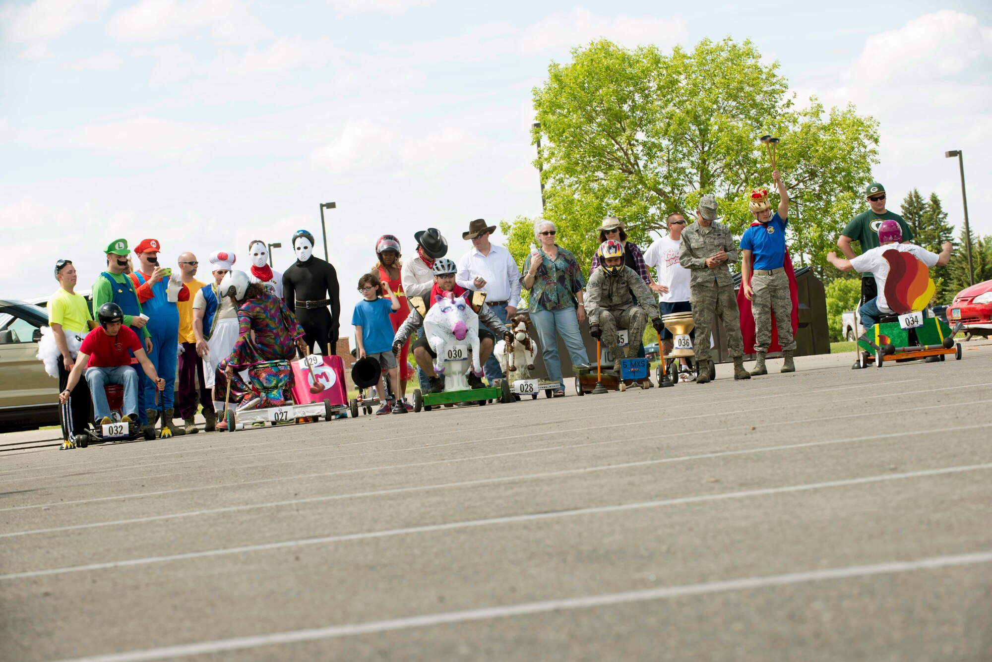 Flusher 100 participants line up at the starting line at Minot Air Force Base, N.D., June 5, 2015. The Flusher 100 was a competition that consisted of participants creating a racing chariot out of a toilet to compete in the race along with a contest for best decorated chariot. (U.S. Air Force photo/Airman 1st Class Sahara L. Fales)