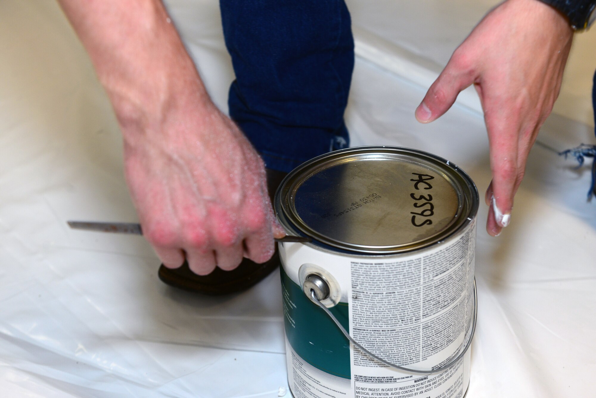 Airman 1st Class Derrick Bellomy, 2nd Operations Support Squadron air traffic controller, opens a can of paint at the Global Power Museum on Barksdale Air Force Base, La., June 10, 2015. Bellomy has spent his week volunteering to renovate the museum. (U.S. Air Force Photo/Airman 1st Class Luke Hill)