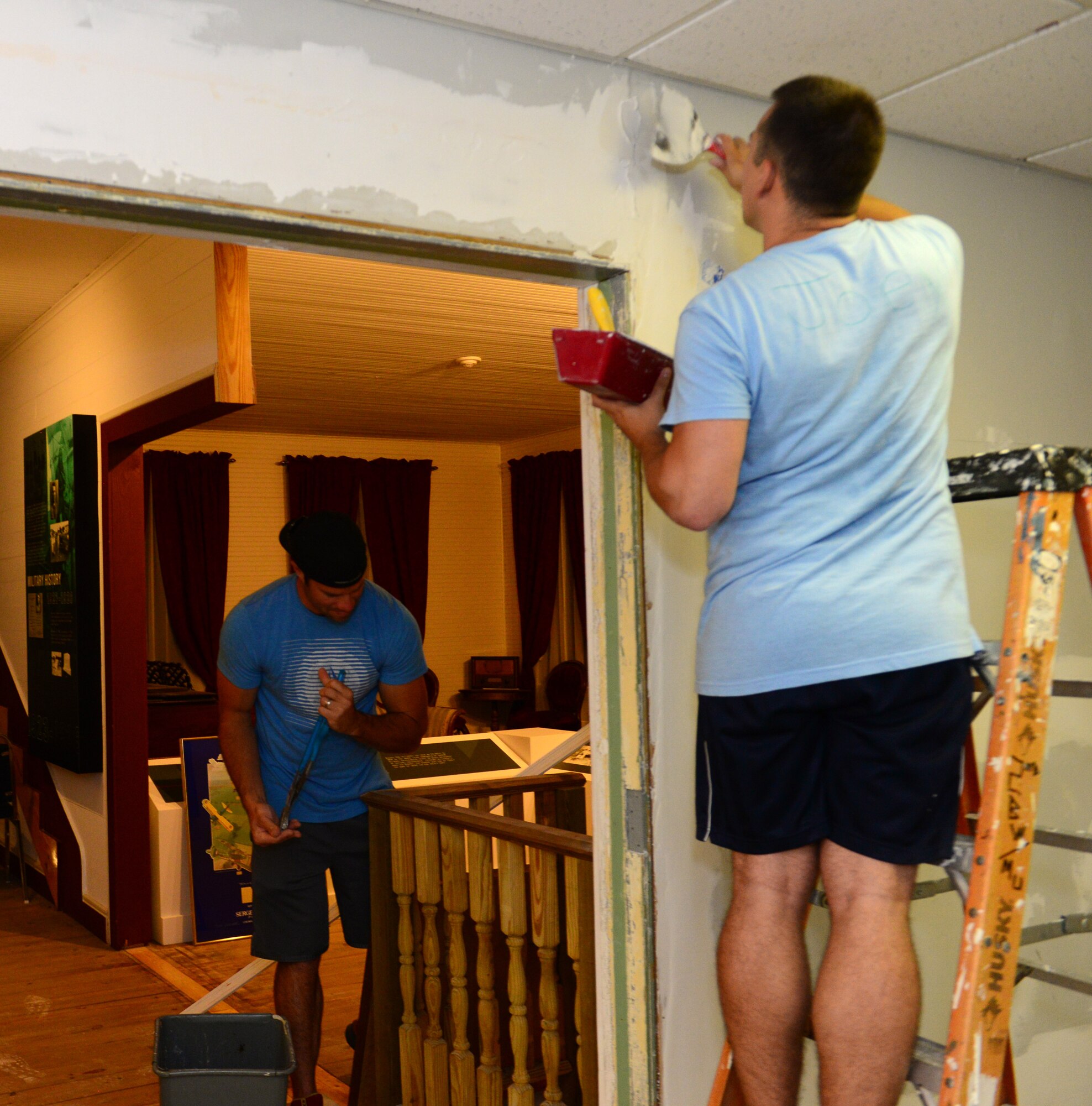 Staff Sgt. James Hulett, left, 20th Aircraft Maintenance Unit, and Airman 1st Class Austin Tanana, 2nd Operations Support Squadron air traffic controller, mud and sand the walls at the Global Power Museum on Barksdale Air Force Base, La., June 8, 2015. The five-day process of renovating the walls of the museum consists of repairing and prepping the walls, texturizing, priming, and painting. (U.S. Air Force Photo/Airman 1st Class Luke Hill)