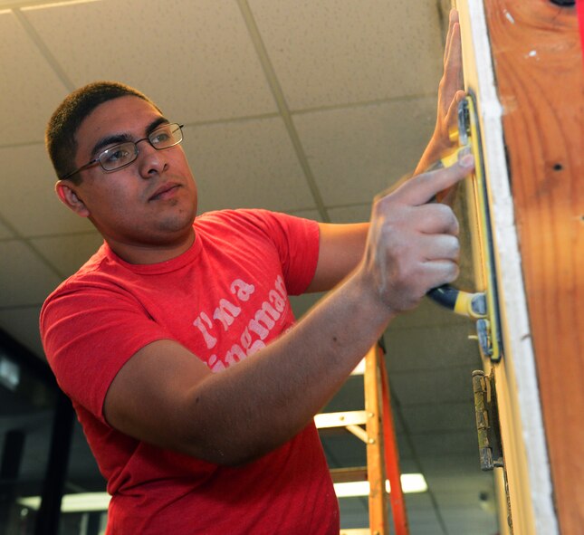 Airman 1st Class Robert Jacome, 2nd Operations Support Squadron air traffic controller, sands down joints at the Global Power Museum on Barksdale Air Force Base, La., June 8, 2015. Airmen from agencies around base volunteered to renovate the walls of the museum. (U.S. Air Force Photo/Airman 1st Class Luke Hill)