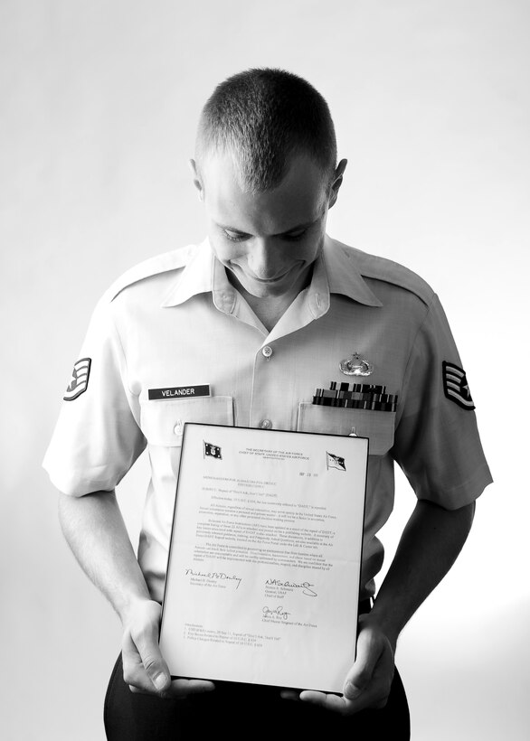 U.S. Air Force Staff Sgt. Eric Velander, 49th Intelligence Squadron, looks down at the letter he received from the Chairman of the Joint Chiefs of Staff when Don’t Ask, Don’t Tell was repealed. Velander was nearly discharged in 2010 for his sexuality. (U.S. Air Force photo by Josh Plueger/Released)
