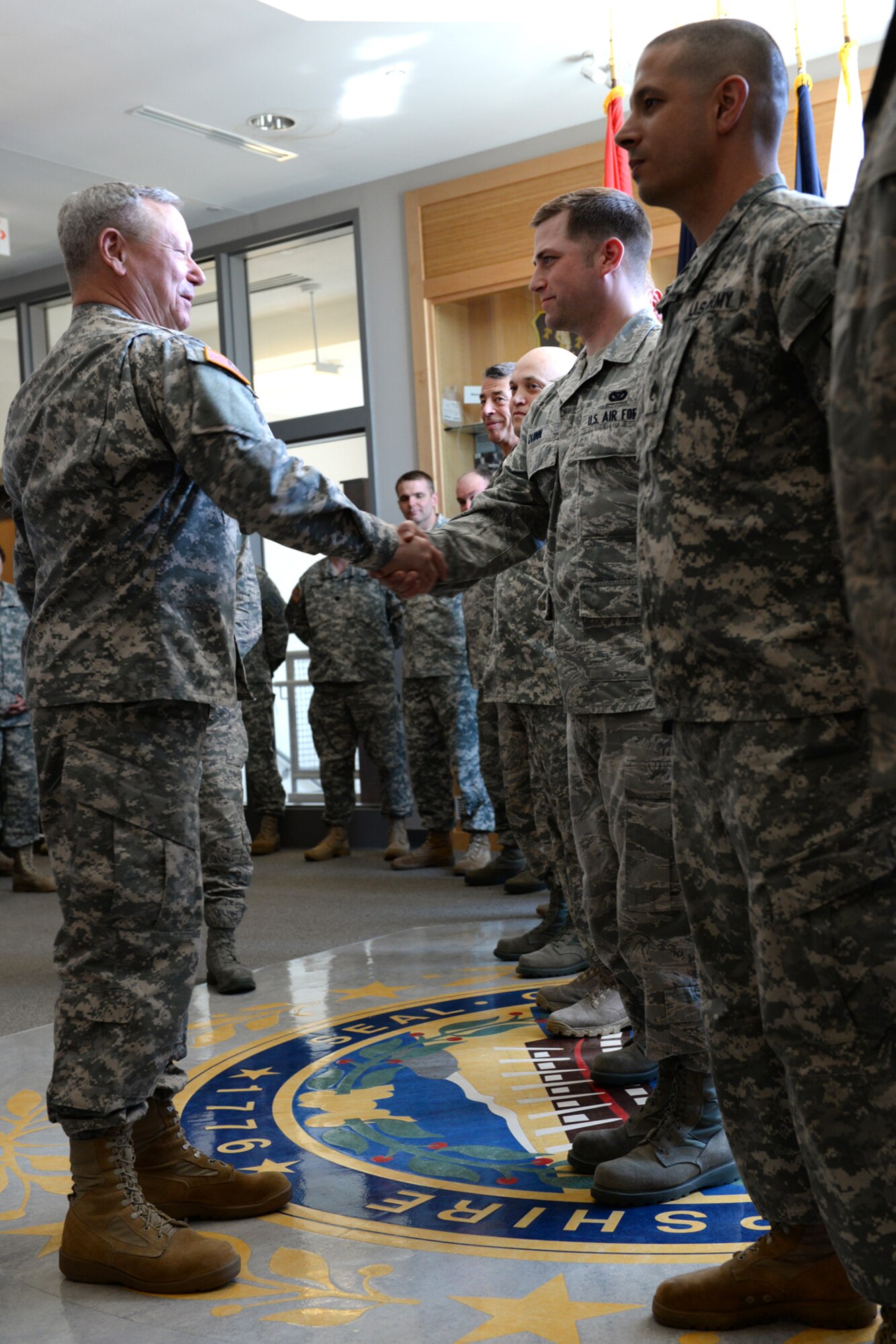 Gen Frank Grass, chief of the National Guard Bureau, presents a commander's coin to Tech. Sgt. Mark Quinn, 157th Civil Engineering Squadron, during a May 3 visit to Joint Force Headquarters in Concord, N.H. (Photo by Senior Airman Kayla McWalter, 157 ARW Public Affairs)
