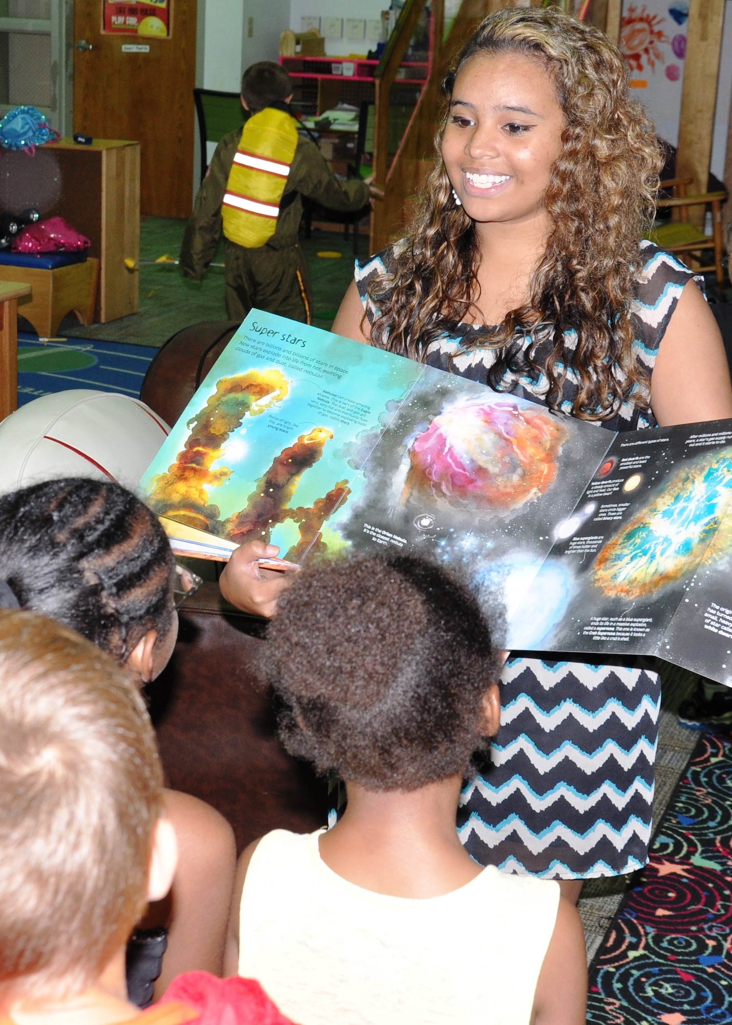 Jocelyn Nimbley, Youth Programs volunteer, reads to children attending the summer School Age Program at the Patrick Air Force Base Youth Center June 11. She was recently selected as the installation winner for the annual Boys and Girls Club of America national competition Military Youth of The Year. As a result, she will attend a week-long Air Force Services sponsored Youth of the Year camp in July. (U.S. Air Force photo/Chrissy Cuttita)