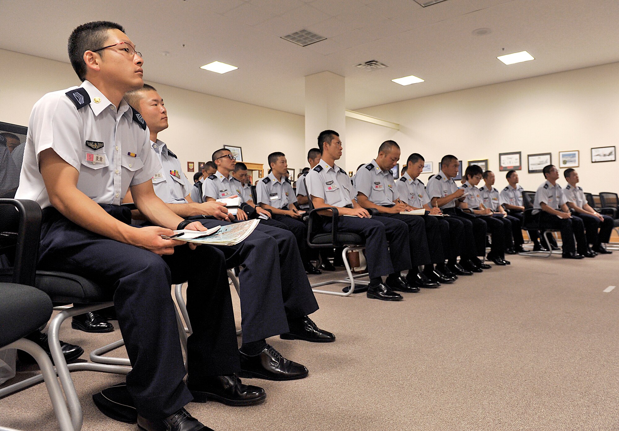 Japan Air Self-Defense Force officer candidate school cadets listen to an 18th Wing mission briefing at Kadena Air Base, Japan, June 11, 2015. More than 70 cadets visited Kadena to help build their relationship with the U.S. Air Force. (U.S. Air Force photo by Naoto Anazawa)