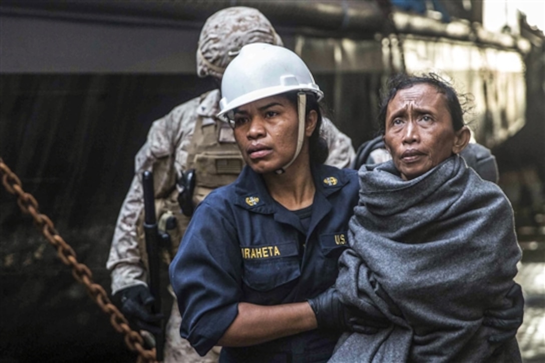 A U.S sailor helps a distressed mariner get to the medical staff aboard the USS Rushmore in the Makassar Strait, June 10, 2015. The Rushmore offered assistance to distressed mariners in the waters between the Indonesian islands of Kalimantan and Sulawesi. Once on board, the mariners received food and medical attention by Marines and sailors assigned to the 15th Marine Expeditionary Unit and Essex Amphibious Ready Group.