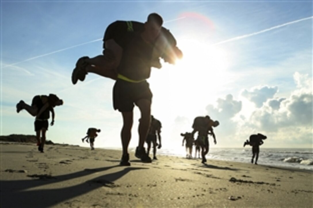 Marines and sailors carry fellow service members using a technique called the fireman’s carry during the commanding general’s run on Onslow Beach, N.C., June 11, 2015. The Marines are assigned to the 2nd Marine Logistics Group.