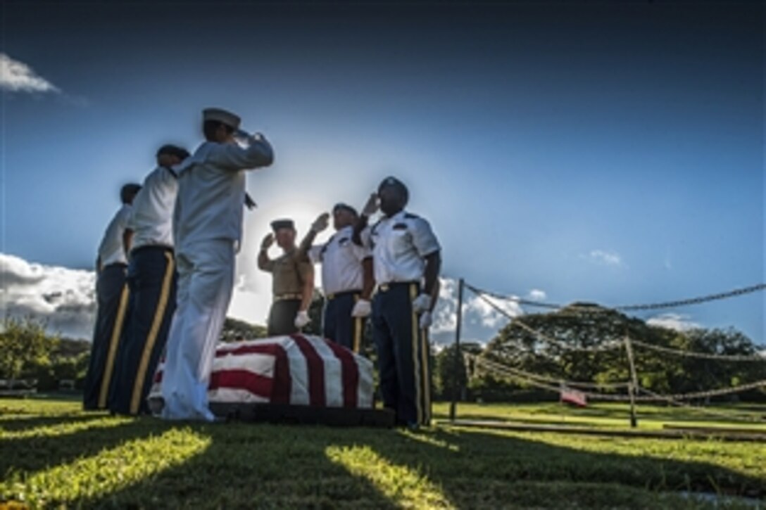 U.S. service members assigned to the Defense POW/ MIA Accounting Agency render honors during a disinterment ceremony at the National Memorial Cemetery of the Pacific in Honolulu, June 8, 2015. The agency conducts disinterments to identify U.S. service members from the USS Oklahoma buried as unknowns.