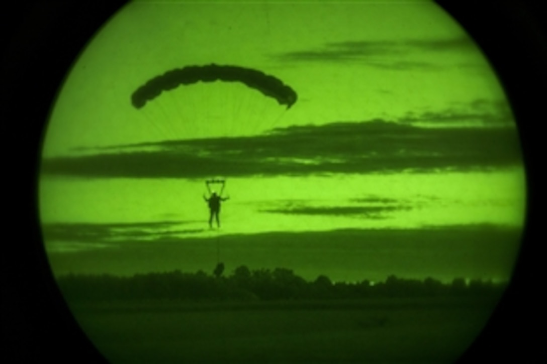 As seen through a night-vision device, a Marine prepares to land on a drop zone in Louisburg, N.C., June 5, 2015, after conducting a jump from a CH-53 Super Stallion helicopter during training.