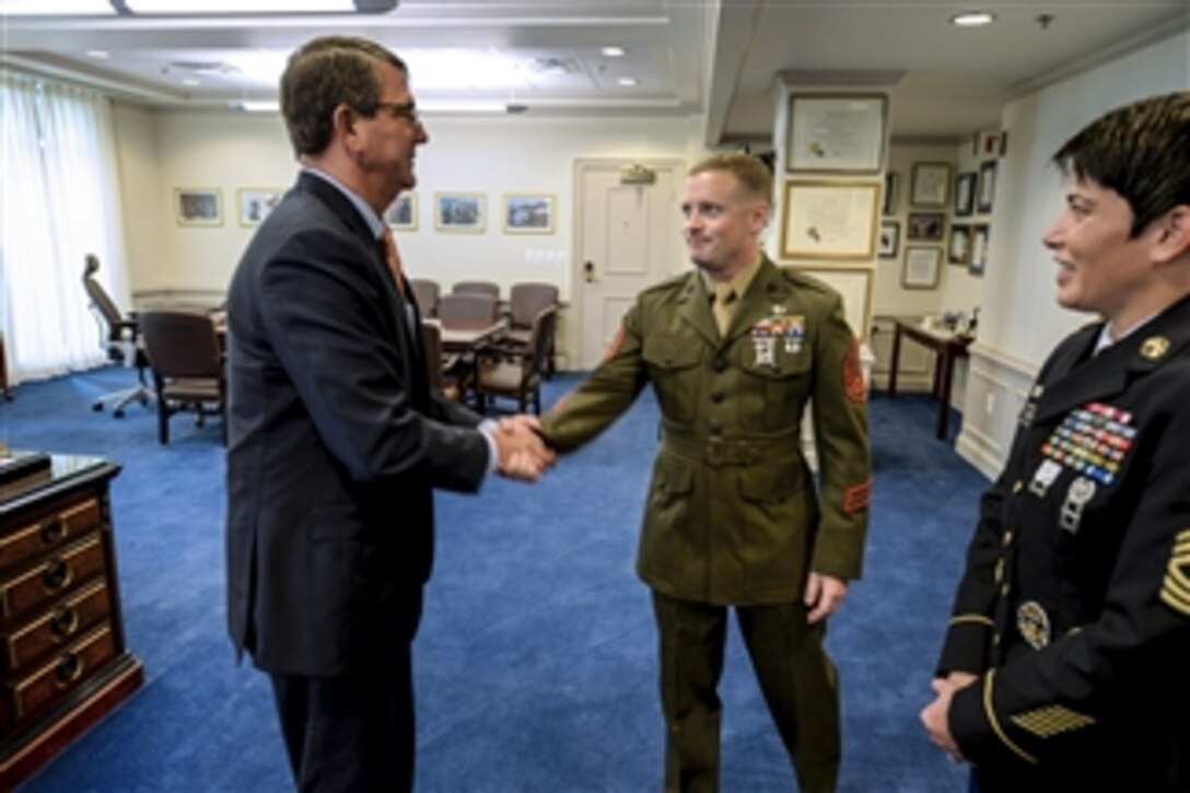 Defense Secretary Ash Carter greets Marine Corps Staff Sgt. Seth B. Densford and Army Master Sgt. Kimberly L. Baker, the junior and senior enlisted service members of the year respectively, at the Pentagon, June 12, 2015.