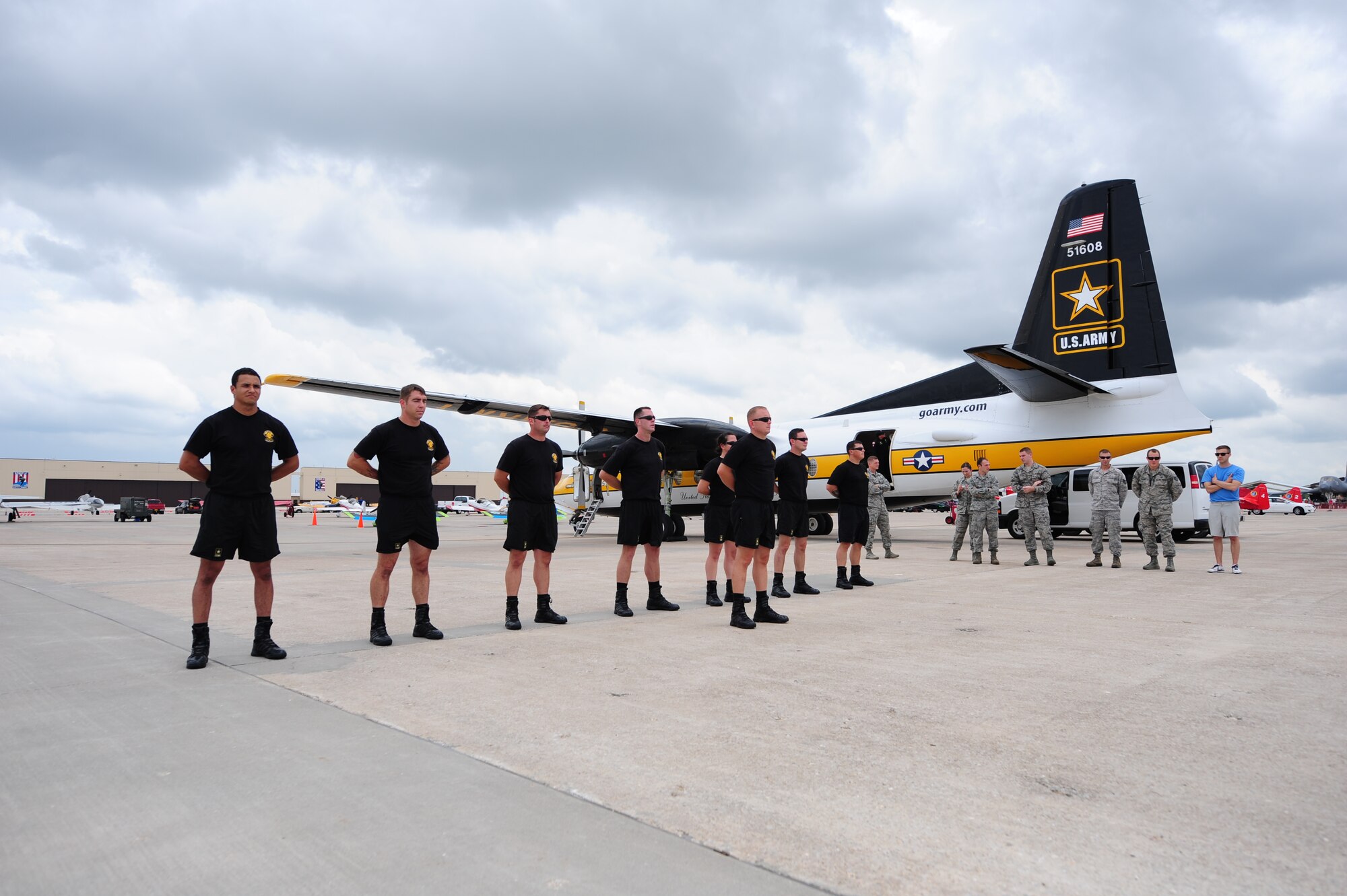 Members of the U.S. Army Golden Knights Parachute Team stand in formation June 13, 2015, during the Wings Over Whiteman air show at Whiteman Air Force Base, Mo. Prior to taking off, the Golden Knights perform a “dirt dive,” which is a practice run on the ground to check each detail of their performance. (U.S. Air Force photo by Airman 1st Class Jazmin Smith/Released)