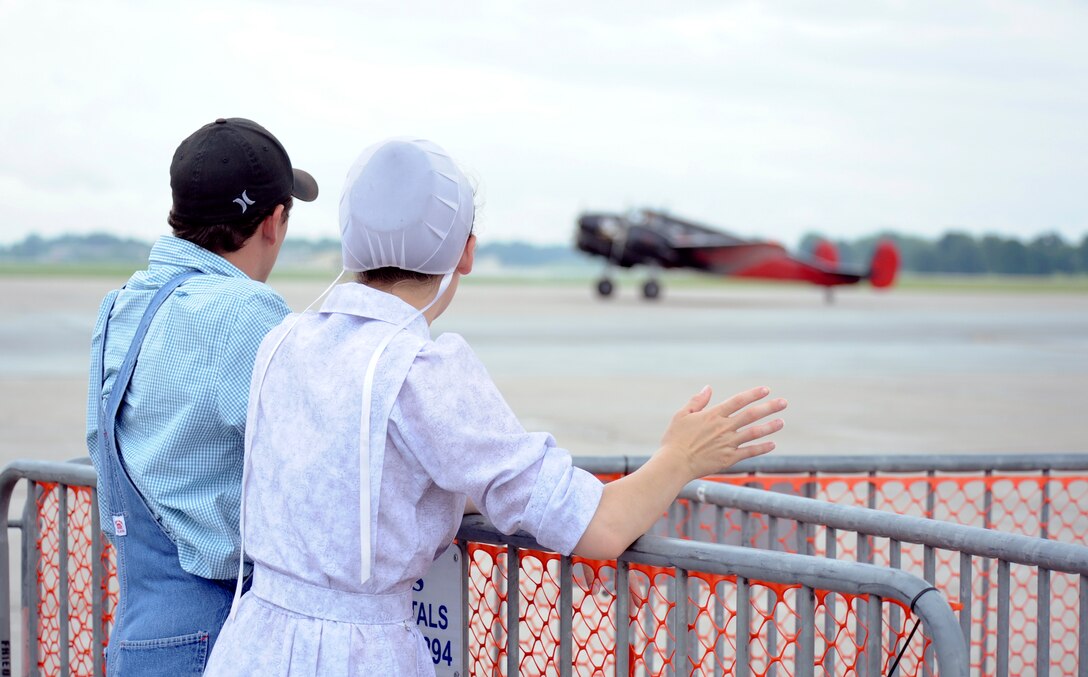 Two spectators at the Wings Over Whiteman watch a Beechcraft Model 18 land after its performance June 13, 2015, at Whiteman Air Force Base, Mo. Although much of the crowd traveled from nearby communities, many traveled here from across the country. (U.S. Air Force photo by Staff Sgt. Brigitte N. Brantley/Released)