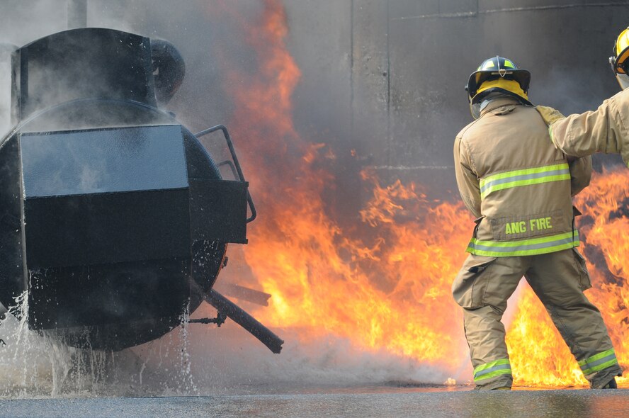 U.S. Air Force and New Jersey state fire protection specialists from the New Jersey Air National Guard's 177th Fighter Wing battle a simulated aircraft fire at Military Sealift Command Training Center East in Freehold, N.J. on June 12. Airmen from the Wing hold annual training here to maintain mission readiness. (U.S. Air National Guard photo by Airman 1st Class Amber Powell/Released)