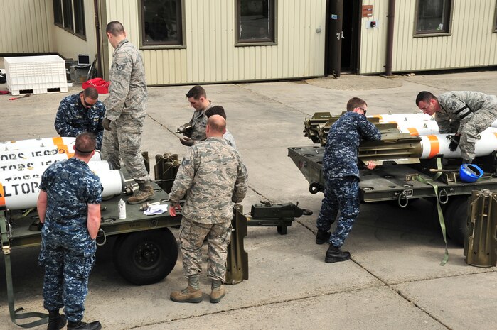 U.S. Navy minemen, from Navy Munitions Command Unit Charleston, and U.S. Air Force technicians, from the 5th Munitions Squadron, attach a MK-15 tail fin to an inert Mark-62 Quick Strike Mine at Royal Air Force Fairford, England, June 10, 2015. The inert mine was loaded onto a B-52H Stratofortress forward deployed to RAF Fairford to participate in multi-national exercises, train with the United States’ allies and partners and showcase the aircraft’s capabilities. (U.S. Air Force photo/Senior Airman Malia Jenkins)  