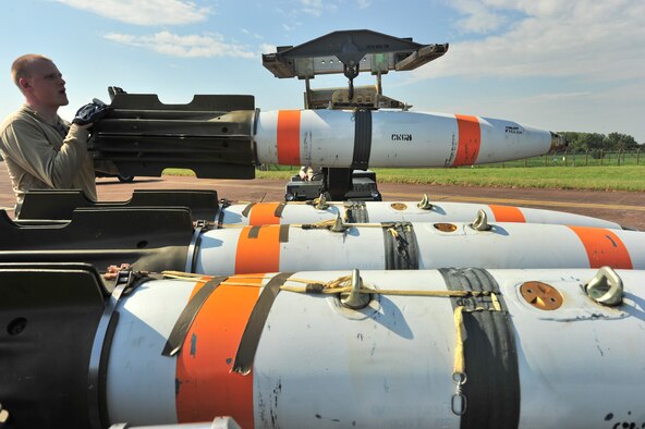 Senior Airman Zachary Kienert, 5th Aircraft Maintenance Squadron weapons load crew member, loads an inert MK-62 Quick Strike Mine onto an MHU-83 at Royal Air Force Fairford, England, June 11, 2015. Weapons load crew members loaded nine inert mines each into two B-52H Stratofortresses for a BALTOPS 15 exercise mission where the crews tested their ability to precisely drop munitions into a target zone off the coast of Sweden.  (U.S. Air Force photo/Senior Airman Malia Jenkins)       
