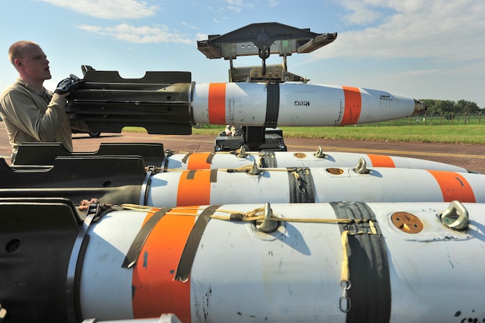 Senior Airman Zachary Kienert, 5th Aircraft Maintenance Squadron weapons load crew member, loads an inert MK-62 Quick Strike Mine onto an MHU-83 at Royal Air Force Fairford, England, June 11, 2015. Weapons load crew members loaded nine inert mines each into two B-52H Stratofortresses for a BALTOPS 15 exercise mission where the crews tested their ability to precisely drop munitions into a target zone off the coast of Sweden.  (U.S. Air Force photo/Senior Airman Malia Jenkins)       