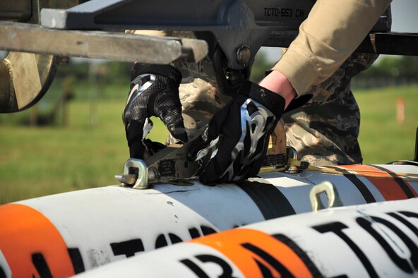 Senior Airman Zachary Kienert, 5th Aircraft Maintenance Squadron weapons load crew member, secures an inert MK-62 Quick Strike Mine to an MHU-83 at Royal Air Force Fairford, England, June 11, 2015. Members from the 5th Munitions Squadron helped U.S. Navy minemen, from Navy Munitions Command Unit Charleston, build 18 inert mines for a BALTOPS 15 exercise testing the B-52H Stratofortress’ ability to precisely drop munitions into a target zone off the coast of Sweden. (U.S. Air Force photo/Senior Airman Malia Jenkins)      