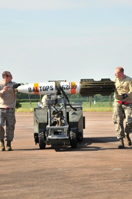 Staff Sgt. Jason Walters, 5th Aircraft Maintenance Squadron weapons load crew chief, and Senior Airman Zachary Kienert, 5th AMXS weapons load crew member, guide an inert MK-62 Quick Strike Mine to a B-52H Stratofortress at Royal Air Force Fairford, England, June 11, 2015. The mines were built for a BALTOPS 15 exercise mission where B-52H Stratofortresses tested their ability to precisely drop munitions into a target zone off the coast of Sweden. BALTOPS provides an opportunity for personnel from different services and nations to engage in realistic maritime training to build experience and teamwork and strengthen interoperability. (U.S. Air Force photo/Senior Airman Malia Jenkins)   