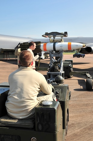 Airman 1st Class Jesse Johnson, 5th Aircraft Maintenance Squadron weapons load crew member, waits for Staff Sgt. Jason Walters, 5th AMXS weapons load crew chief, to strap down an inert MK-62 Quick Strike Mine to an MJ-1 lift truck at Royal Air Force Fairford, England, June 11, 2015. The B-52H Stratfortress was one of two which used the inert mines in the BALTOPS 15 exercise, testing their ability to precisely drop munitions into a target zone off the coast of Sweden. Three B-52s were forward deployed to RAF Fairford from Minot Air Force Base, N.D., to participate in multi-national exercises, train with the United States’ allies and partners and showcase the aircraft’s capabilities. (U.S. Air Force photo/Senior Airman Malia Jenkins)  
