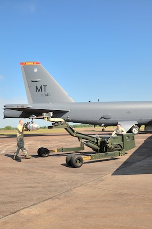 Senior Airman Zachary Kienert, 5th Aircraft Maintenance Squadron weapons load crew member, helps guide an inert MK-62 Quick Strike Mine to be loaded onto an MJ-1 lift truck at Royal Air Force Fairford, England, June 11, 2015. U.S. Navy minemen, from Navy Munitions Command Unit Charleston, worked with Airmen from the 5th Munitions Squadron, to build the munitions, which were used by the B-52H Stratofortress and its crew in a BALTOPS 15 exercise. BALTOPS demonstrates America’s shared commitment with NATO allies and partners to promote peace and security in the region. (U.S. Air Force photo/Senior Airman Malia Jenkins)   