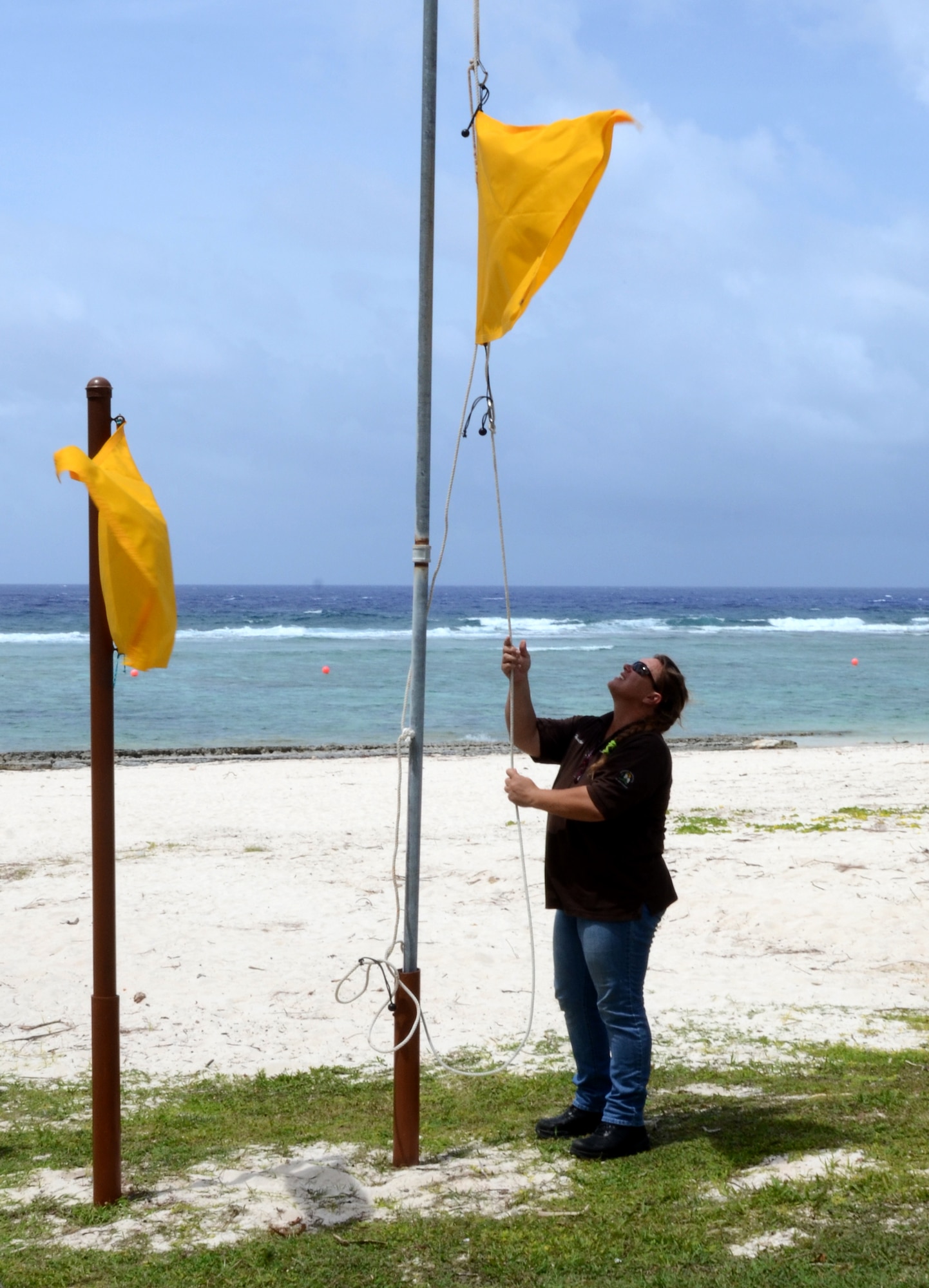 Heather Colson, 36th Force Support Squadron aquatic director, changes water-condition warning flags at Tarague Beach on Andersen Air Force Base, Guam, June 11, 2015. The flags indicate what the current water conditions are at Tarague so Airmen and their families are able to enjoy the beach safely. (U.S. Air Force photo by Airman 1st Class Alexa Ann Henderson/Released)