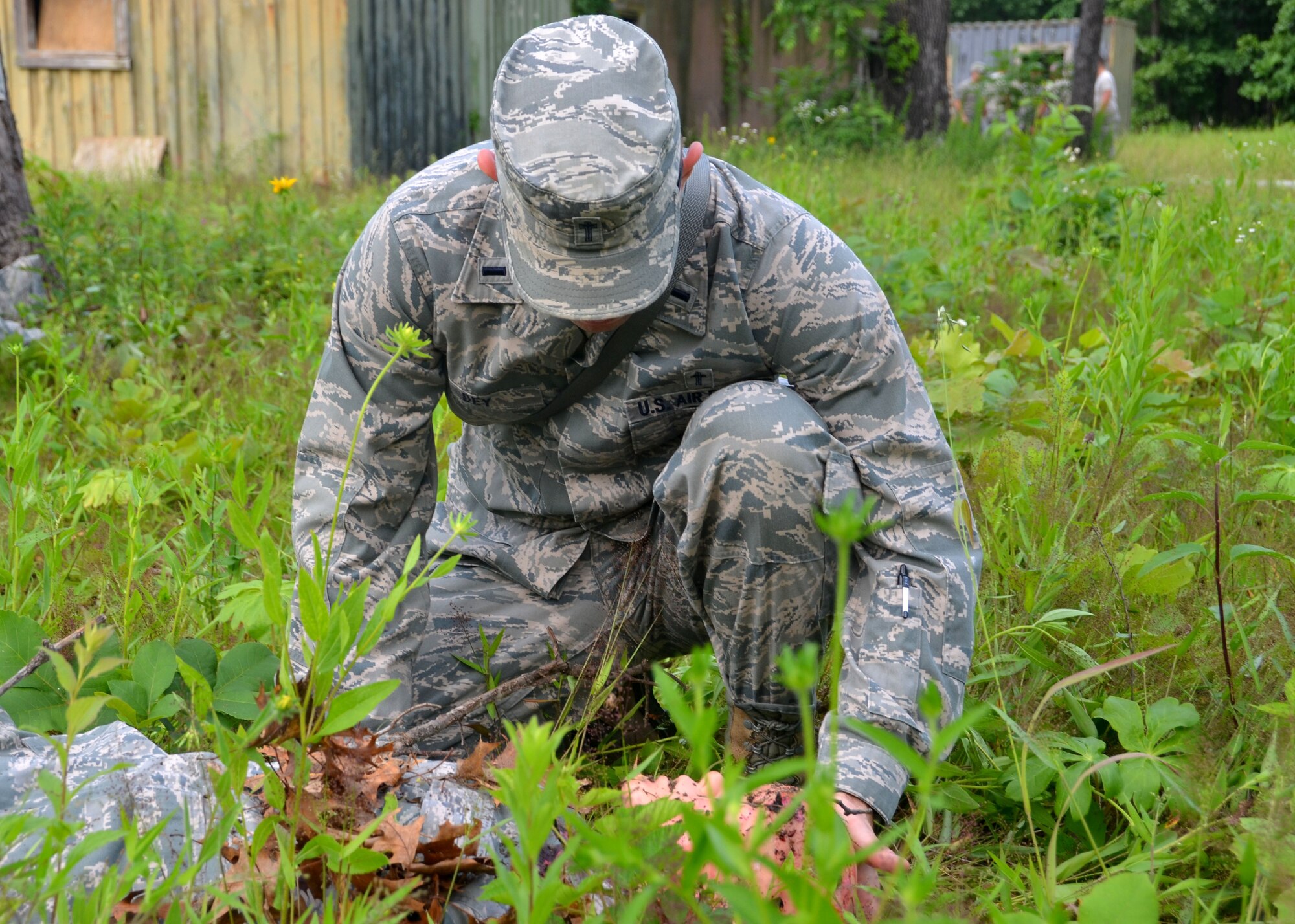 Chaplain 1st Lt. Charlie Dey, 131st Bomb Wing chaplain, administers last rights to a simulated victim of tornado destruction during a mass casualty exercise at Camp Clark, Missouri, June 4, 2015.  Airmen with the 131st Bomb Wing participated in annual training to prepare them for their state mission of providing aid to their communities when called upon by the governor.  (U.S. Air National Guard photo by Tech.  Sgt. Traci Payne)