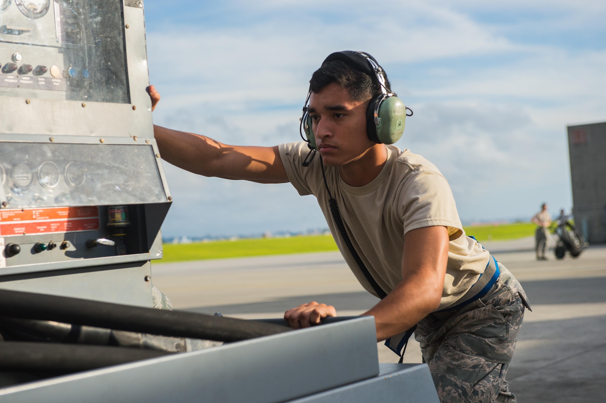 U.S. Air Force Airman 1st Class Eugene Alvarado, an Aerospace Maintenance Apprentice from the 353rd Special Operations Maintenance Squadron pushes a power cart on the Kadena Air Base, Japan, flightline before an MC-130H Combat Talon II formation flight May 14, 2015. By conducting formation flight, aircrews and maintainers test and validate their ability to efficiently generate aircraft and to quickly infiltrate and exfiltrate large numbers of ground forces. (U.S. Air Force photo by Airman 1st Class Tyler Woodward)