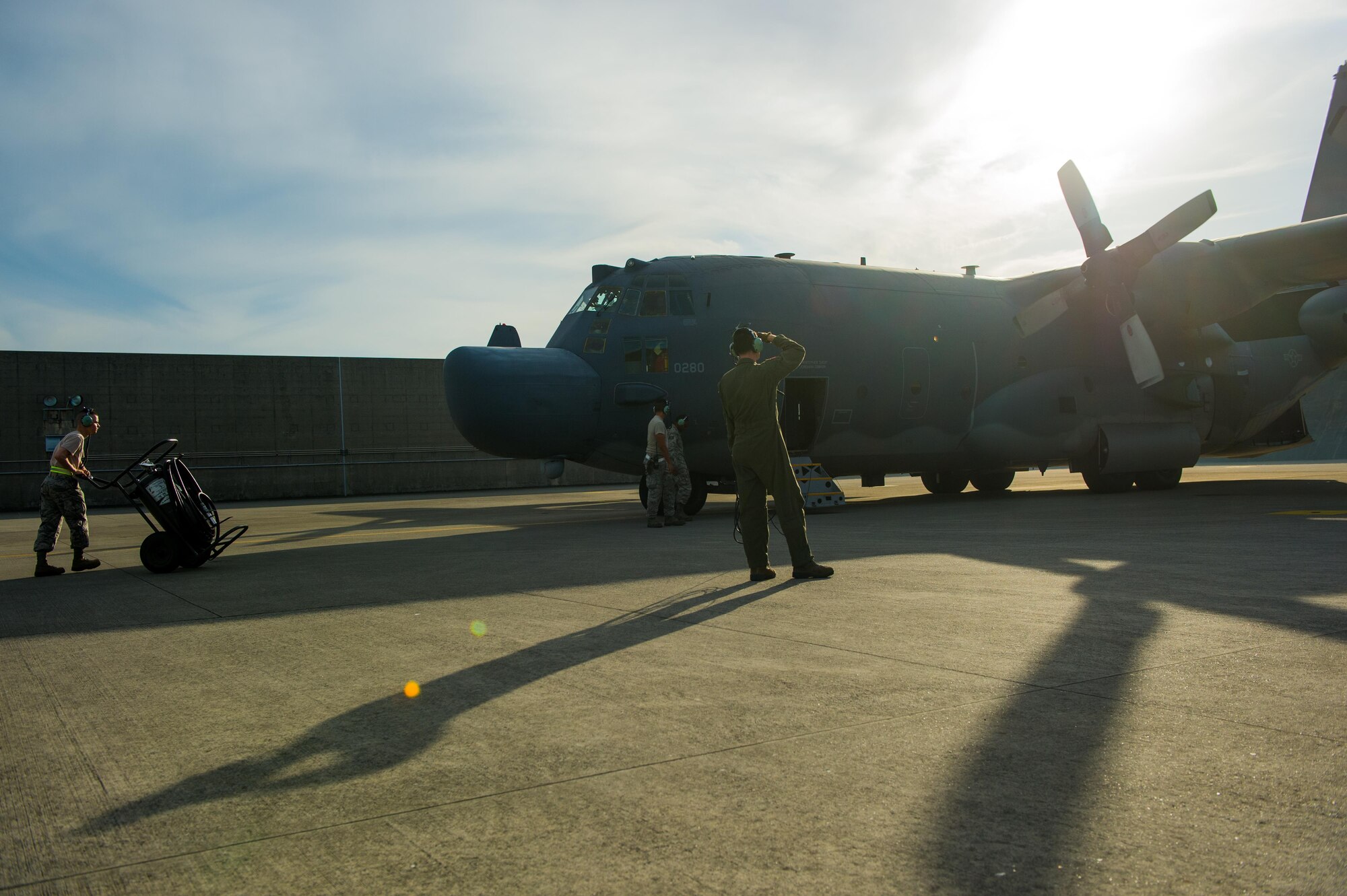 Two U.S. Air Force Airmen from the 1st Special Operations Squadron and the 353rd Special Operations Maintenance Squadron watch as the MC-130H Combat Talon II engine starts before a formation flight at Kadena Air Base, Japan, May 14, 2015. The 1st SOS and the 353rd SOMXS are part of the 353rd Special Operations Group.  As the only Air Force special operations group in the Pacific, they are the focal point for Air Force special operations activities throughout the United States Pacific Command Theater.     (U.S. Air Force photo by Airman 1st Class Tyler Woodward)
