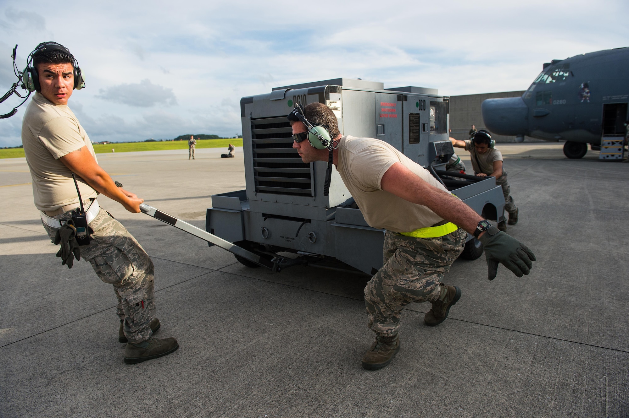 From left, U.S. Air Force Airmen 1st Class Eugene Alvarado and Nicholas Martinez, both aerospace maintenance apprentices along with Senior Airman Patrick Huber, Aerospace Propulsion Journeyman from the 353rd Special Operations Maintenance Squadron work together to move a power cart away from the aircraft on the Kadena Air Base, Japan, flightline before a formation flight May 14, 2015.  By conducting formation flight, aircrews and maintainers test and validate their ability to efficiently generate aircraft and to quickly infiltrate and exfiltrate large numbers of ground forces.    (U.S. Air Force photo by Airman 1st Class Tyler Woodward)