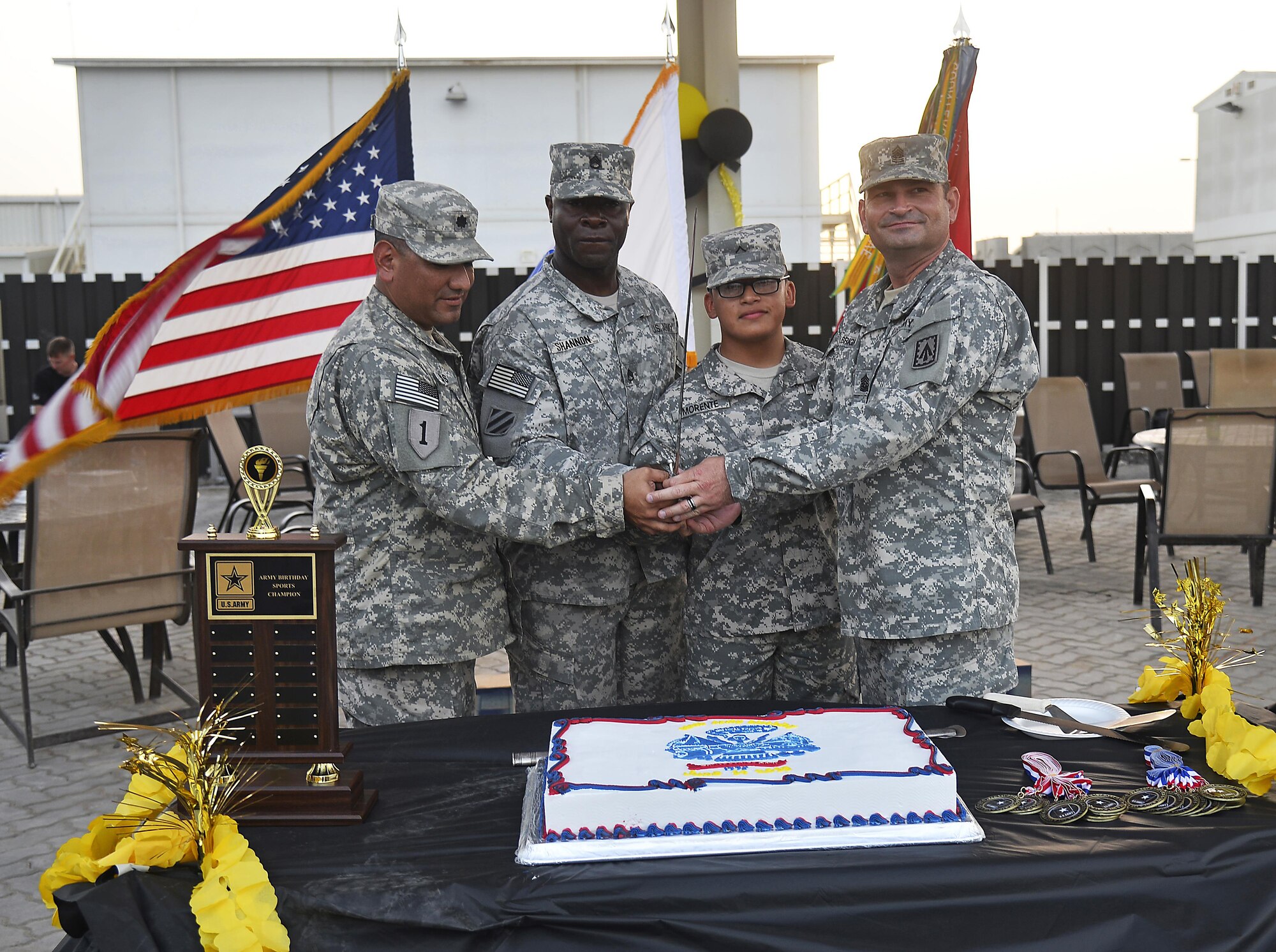 From left to right Lt. Col. Mike Solis, Staff Sgt. George, Private Ronnie, and Command Sgt. Maj. Paul Albright cut the 240th U.S. Army birthday cake at an undisclosed location in Southwest Asia June 13, 2015. The 1st Battalion, 7th Air Defense Artillery Regiment hosted a two-day sporting event culminated by a closing ceremony to celebrate their 240th birthday. (U.S. Air Force photo/Tech. Sgt. Jeff Andrejcik)