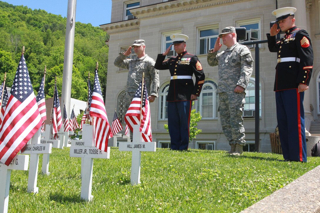 U.S. Marine Corps Gunnery Sgt. Robert Hahn, 38, a Killeen, Texas, native and staff noncommissioned officer in charge of Recruiting Sub-station Huntington, West Virginia, second from left, and U.S. Marine Corps Sgt. Joseph A. Wood, right, a recruiter with RSS Huntington and native of Huntington, West Virginia, salute memorial flags May 20, 2015, outside of the Boone County courthouse in Madison, West Virginia. Boone County officials reached out to local members of the armed forces in an effort to reduce the number of at-risk youth in the community.   (U.S. Marine Corps photo by Sgt. Caitlin Brink/Released) 