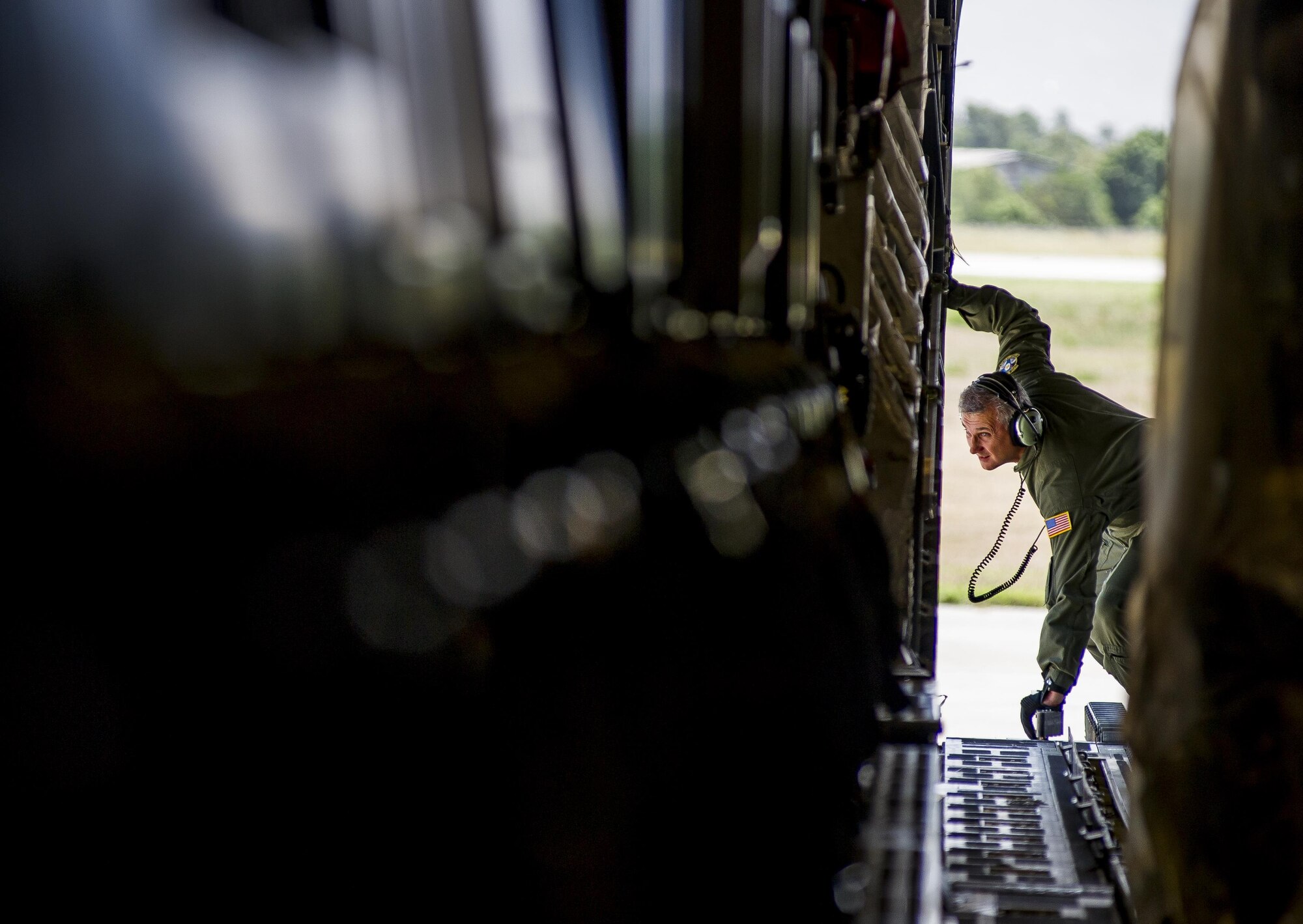 Senior Master Sgt. Randy Thigpen, 317th Airlift Squadron loadmaster, watches through the back of a C-17 Globemaster III June 13, 2015, as it taxis into position in Port Di Prince, Haiti. The 317th AS delivered more than 65,000 pounds of food to the civilians of Haiti, then continued their mission to Saint Kitts and Nevis and provided bicycles, school and medical supplies. (U.S. Air Force photo / Senior Airman Tom Brading)