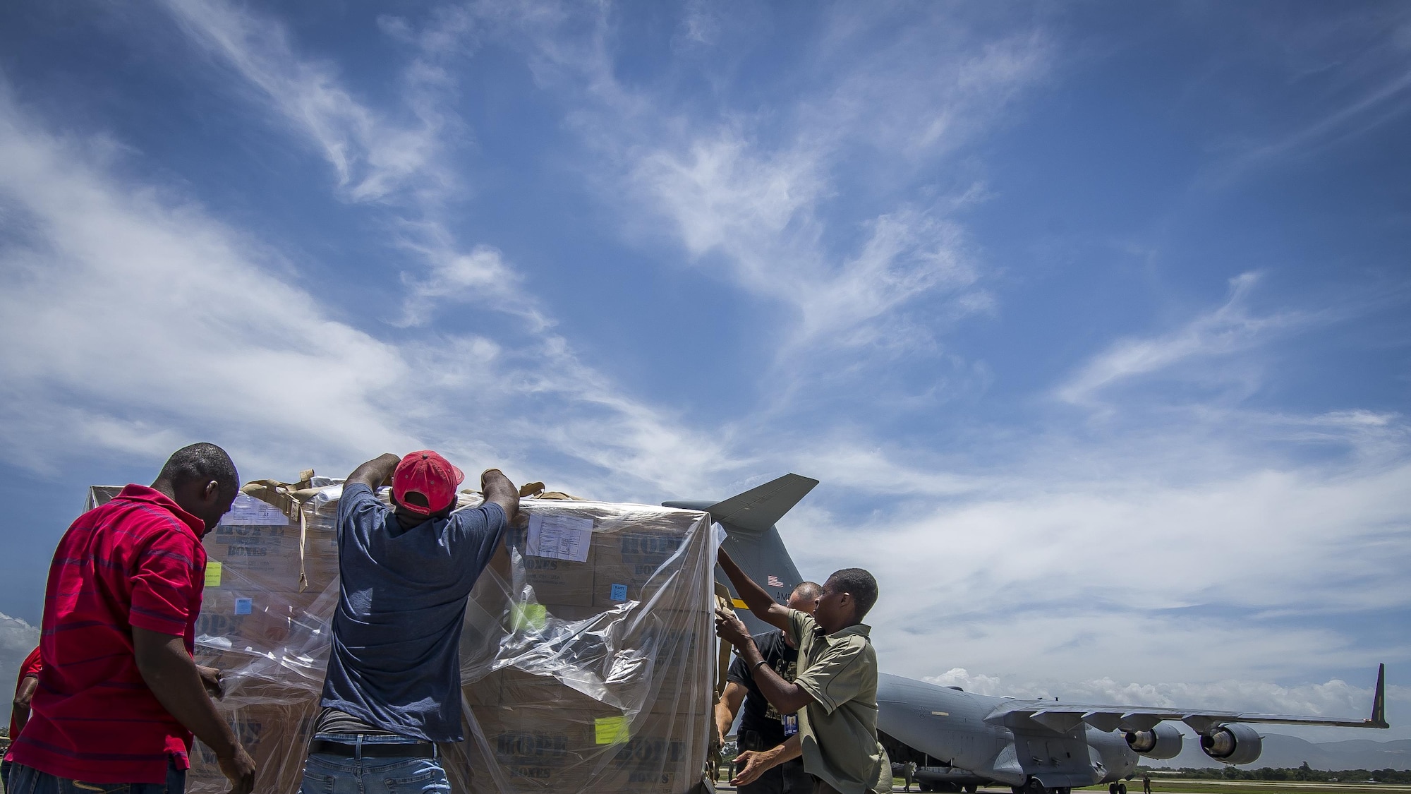 Haitian civilians unload more than 65,000 pounds of food June 13, 2015, at Port Au Prince, Haiti, during a humanitarian aid mission conducted by the 317th Airlift Squadron. After successfully unloading the cargo, the aircrew then took more humanitarian aid to Saint Kitts and Nevis. (U.S. Air Force photo by Senior Airman Tom Brading)