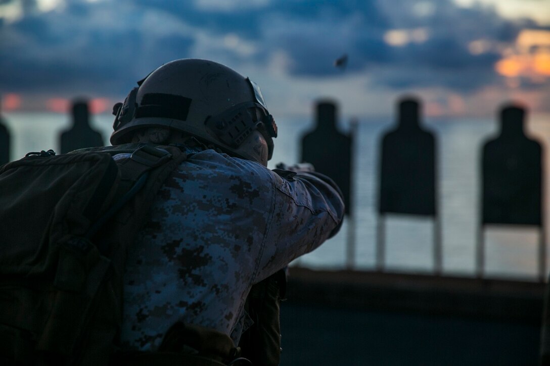 A U.S. Marine with the 15th Marine Expeditionary Unit’s Maritime Raid Force fires at his target on the flight deck of the USS Essex (LHD 2) in the South China Sea, June 12, 2015. The MRF practiced precision, slow-fire shooting, and drills which included shooting on the move and multiple-target engagements. (U.S. Marine Corps photo by Cpl. Anna Albrecht/Released)