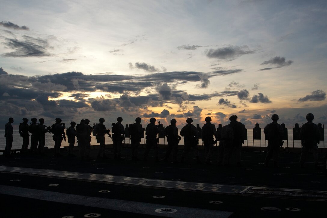 U.S. Marines with the 15th Marine Expeditionary Unit’s Maritime Raid Force aim at targets on the flight deck of the USS Essex (LHD 2) in the South China Sea, June 12, 2015. The MRF practices both pistol and rifle marksmanship skills frequently to improve their speed and accuracy. (U.S. Marine Corps photo by Cpl. Anna Albrecht/Released)