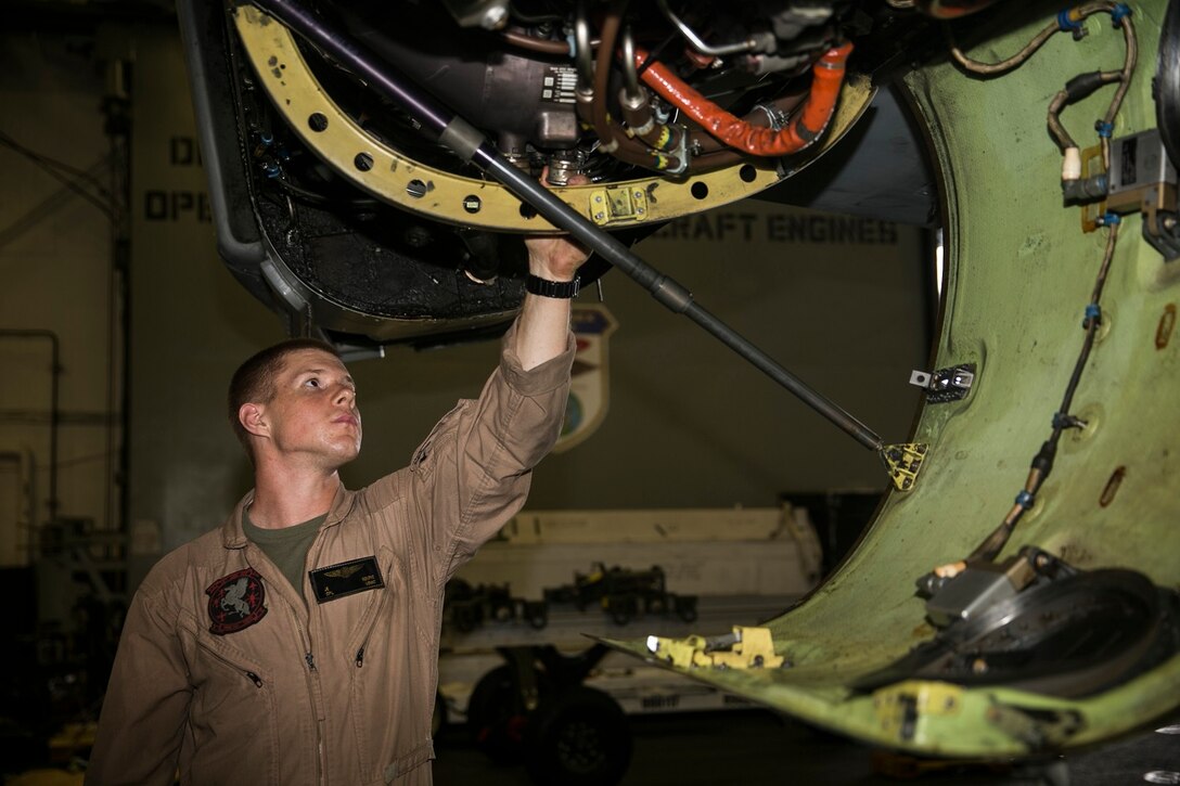 U.S. Marine Cpl. James Koepke inspects a MV-22B Osprey aboard the USS Essex (LHD 2) in the South China Sea, June 13, 2015. Koepke is a crew chief with Marine Medium Tiltrotor Squadron 161 (Reinforced), 15th Marine Expeditionary Unit. Prior to taking off, each aircraft is routinely inspected to ensure a safe flight. (U.S. Marine Corps photo by Cpl. Anna Albrecht/Released)