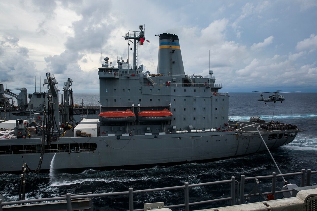 An MH-60S Sea Hawk picks up supplies and mail from the USNS Walter S. Diehl (T-AO 193) to transport them to the USS Essex (LHD 2) during a replenishment-at-sea in the South China Sea, June 14, 2015. U.S. Marines and Sailors aboard the Essex worked together to distribute the supplies throughout the ship as they transition to their 5th Fleet area of responsibility. (U.S. Marine Corps photo by Cpl. Anna Albrecht/ Released)