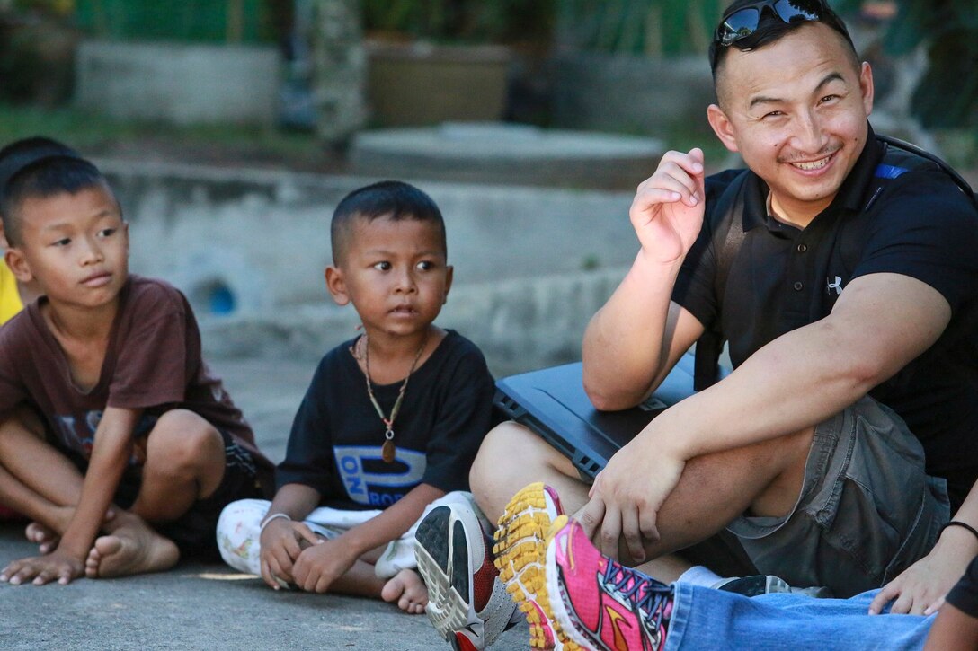 U.S. Navy Hospital Corpsman 3rd Class Michael Her sits in a circle with Thai children from the Fountain of Life Children’s Center in Pattaya, Thailand, June 10, 2015. Her is a corpsman with Battalion Landing Team 3rd Battalion, 1st Marine Regiment, 15th Expeditionary Unit. Some of Marines and Sailors aboard the USS Anchorage (LPD 23) volunteered to spend time with these children during a recent port visit in Thailand. These volunteer programs help foster better relationships with host nations throughout the 7th Fleet area of operation.  (U.S. Marine Corps photo by Sgt. Steve H. Lopez/Released)