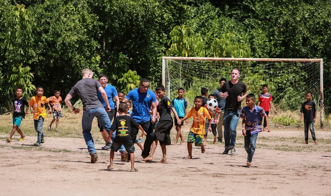 The Marines and Sailors of the 15th Marine Expeditionary Unit and Essex Amphibious Ready Group play soccer with children from the Fountain of Life Children’s Center in Pattaya, Thailand, June 10, 2015. Some of Marines and Sailors aboard the USS Anchorage (LPD 23) volunteered to spend time with these children during a recent port visit in Thailand. These volunteer programs help foster better relationships with host nations throughout the 7th Fleet area of operation.  (U.S. Marine Corps photo by Sgt. Steve H. Lopez/Released)