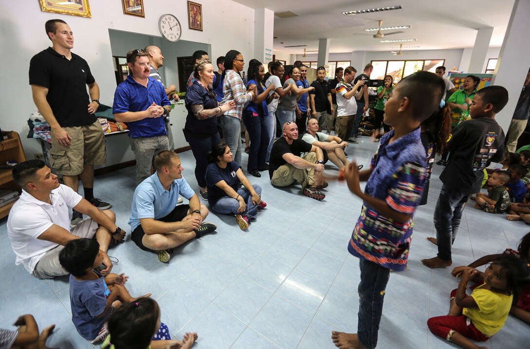 U.S. Marines and Sailors of the 15th Marine Expeditionary Unit and Essex Amphibious Ready Group sing with children from the Fountain of Life Children’s Center in Pattaya, Thailand, June 10, 2015. Some of Marines and Sailors aboard the USS Anchorage (LPD 23) volunteered to spend time with these children during a recent port visit in Thailand. These volunteer programs help foster better relationships with host nations throughout the 7th Fleet area of operation.  (U.S. Marine Corps photo by Sgt. Steve H. Lopez/Released)