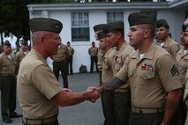 Major General Lawrence D. Nicholson, the commanding general of the 1st Marine Division, congratulates a Marine chosen from the division to attend the new Squad Leader Development Program, aboard Marine Corps Base Camp Pendleton, Calif., June 12, 2015. The program will allow qualified Marines to develop a career path as an infantry squad leader.