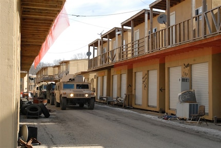 A convoy moves down a mock alleyway at Muscatatuck Urban Training Center, Ind., Feb. 10, 2011. Instructors strive to make the scenery as authentic as possible for students attending the Civilian Expeditionary Workforce predeployment training course at Muscatatuck and nearby Camp Atterbury.