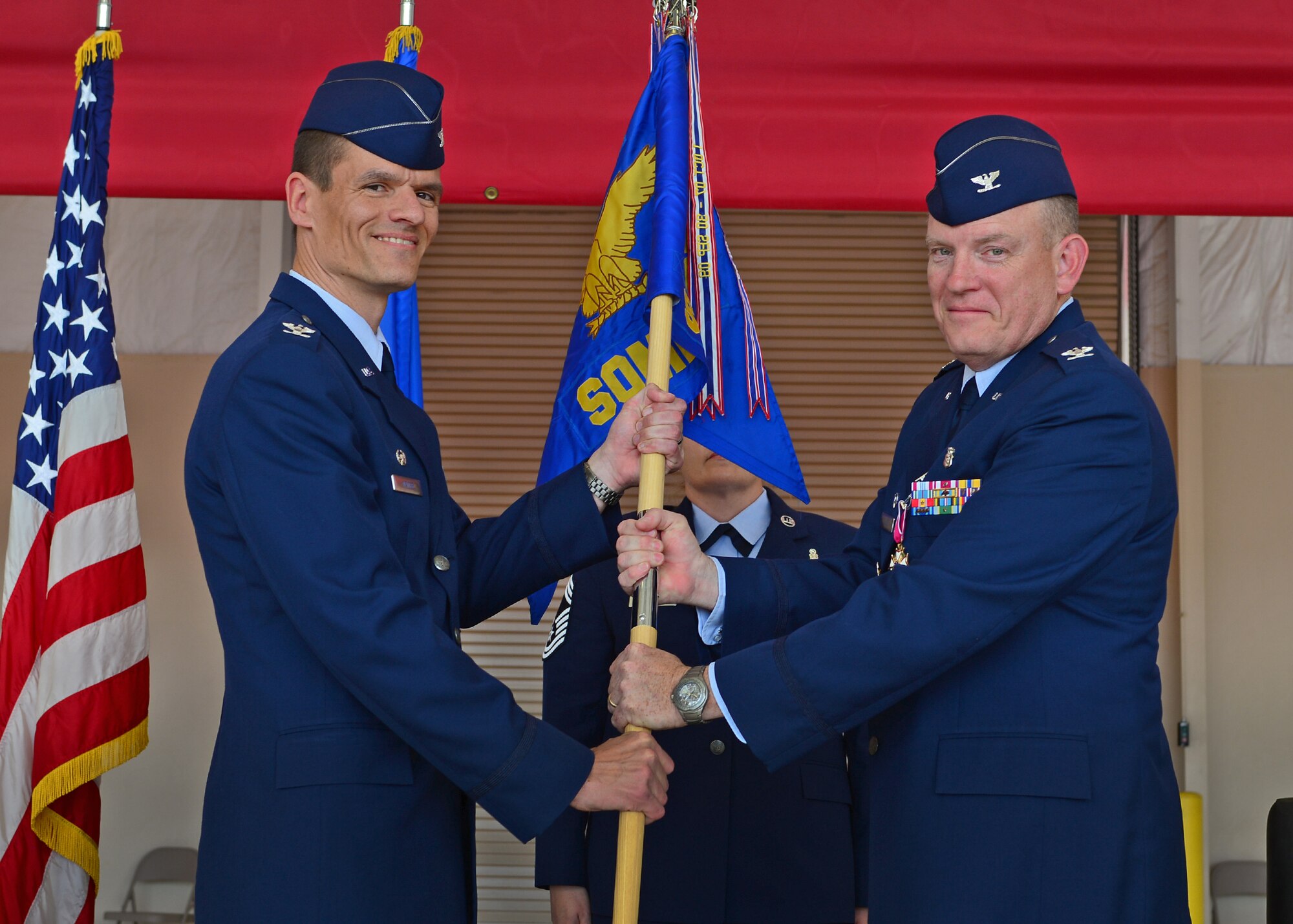 U.S. Air Force Col. Jeffrey Gillen, 27th Special Operations Medical Group commander, relinquishes the guideon to Col. Ben Maitre, 27th Special Operations Wing commander, during the 27th SOMDG change of command ceremony May 29, 2015 at Cannon Air Force Base, N.M. Col. John Mammano assumed command of the 27th SOMDG and will help provide medical care to Air Commandos of the 27th SOW, and a total beneficiary population of 13,500 in the northeastern region of New Mexico and the panhandle of northern Texas. (U.S. Air Force photo/Senior Airman Eboni Reece)  