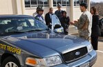 Sgt. Mike Turner, a road officer with the Missouri Highway Patrol, describes
the capabilities of his patrol car to members of the State Partnership
Program between the Missouri National Guard and Panama Lt. Vince Rice,
assistant director of professional standards division, watches on as Army
2nd. Lt. Arturo Ibarra of the Missouri National Guard translates in
Jefferson City March 2.