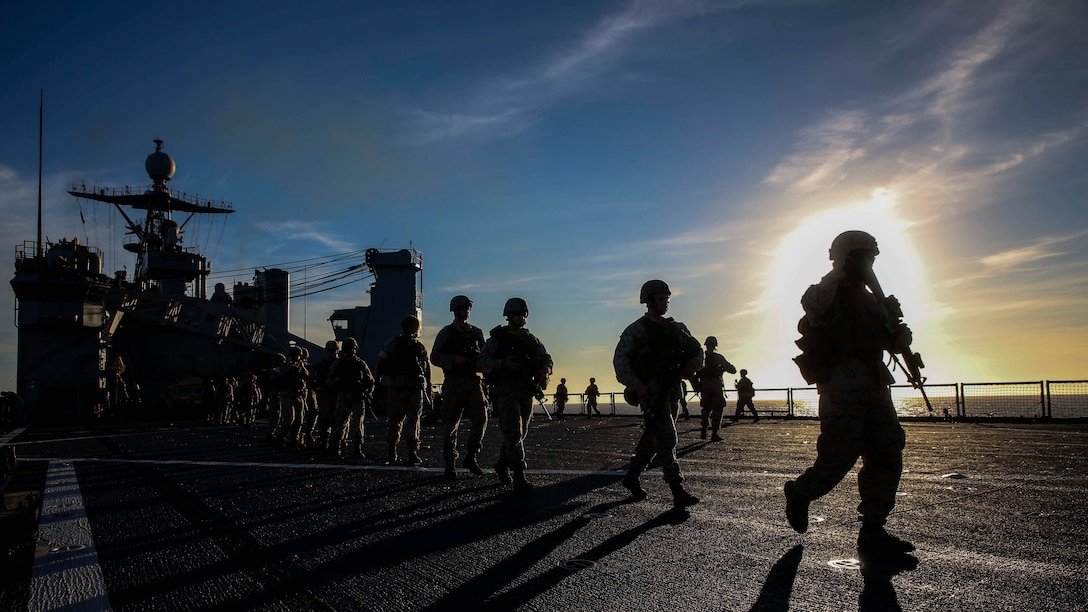 U.S. Marines walk to the flight deck of the USS Ashland to participate in a combat marksmanship program range June 13, 2015. The Marines with Echo Company, Battalion Landing Team 2nd Battalion, 5th Marines, 31st Marine Expeditionary Unit, executed several different shooting drills during the training. The battalion is currently assigned to the 31st MEU as the ground combat element.  The 31st MEU is on the regularly scheduled Fall Patrol of the Asia-Pacific region. 