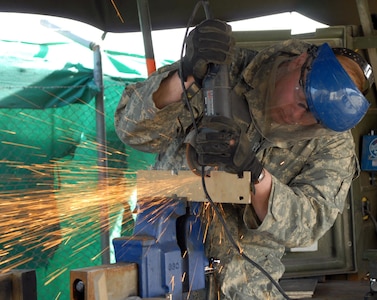 Iowa Army National Guard Spc. Chad Vieth, a metal worker with Company B,
334th Brigade Support Battalion, Task Force Archer, a part of the 2nd Brigade
Combat Team, 34th Infantry Division, Task Force Red Bulls, grinds metal at
Company B's forward repair station on Bagram Air Field, Afghanistan, March
11, 2011.